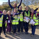 Cheddington Scout Group in high vis jackets cheering with hands in the air