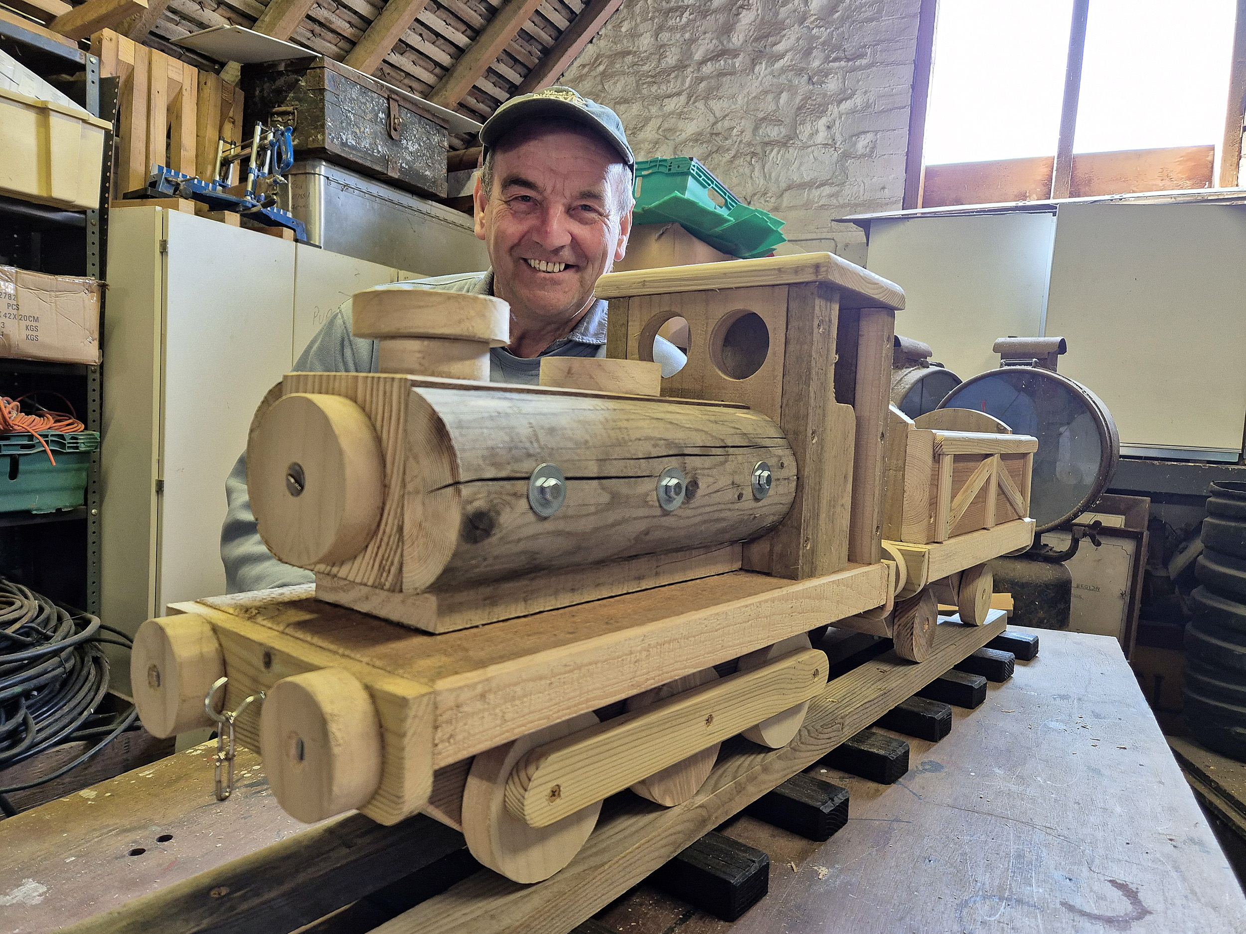 Men in Sheds Leighton Buzzard featuring a wooden hand made wooden train with smiling maker