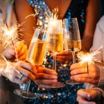 FRIENDS HOLDING GLASSES OF CHAMPAGNE AND SPARKLERS CELEBRATE NEW YEARS EVE IN lEIGHTON BUZZARD
