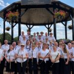 leighton linslade concert band lined up in white shirts at the bandstand in parsons close rec