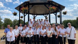 leighton linslade concert band lined up in white shirts at the bandstand in parsons close rec