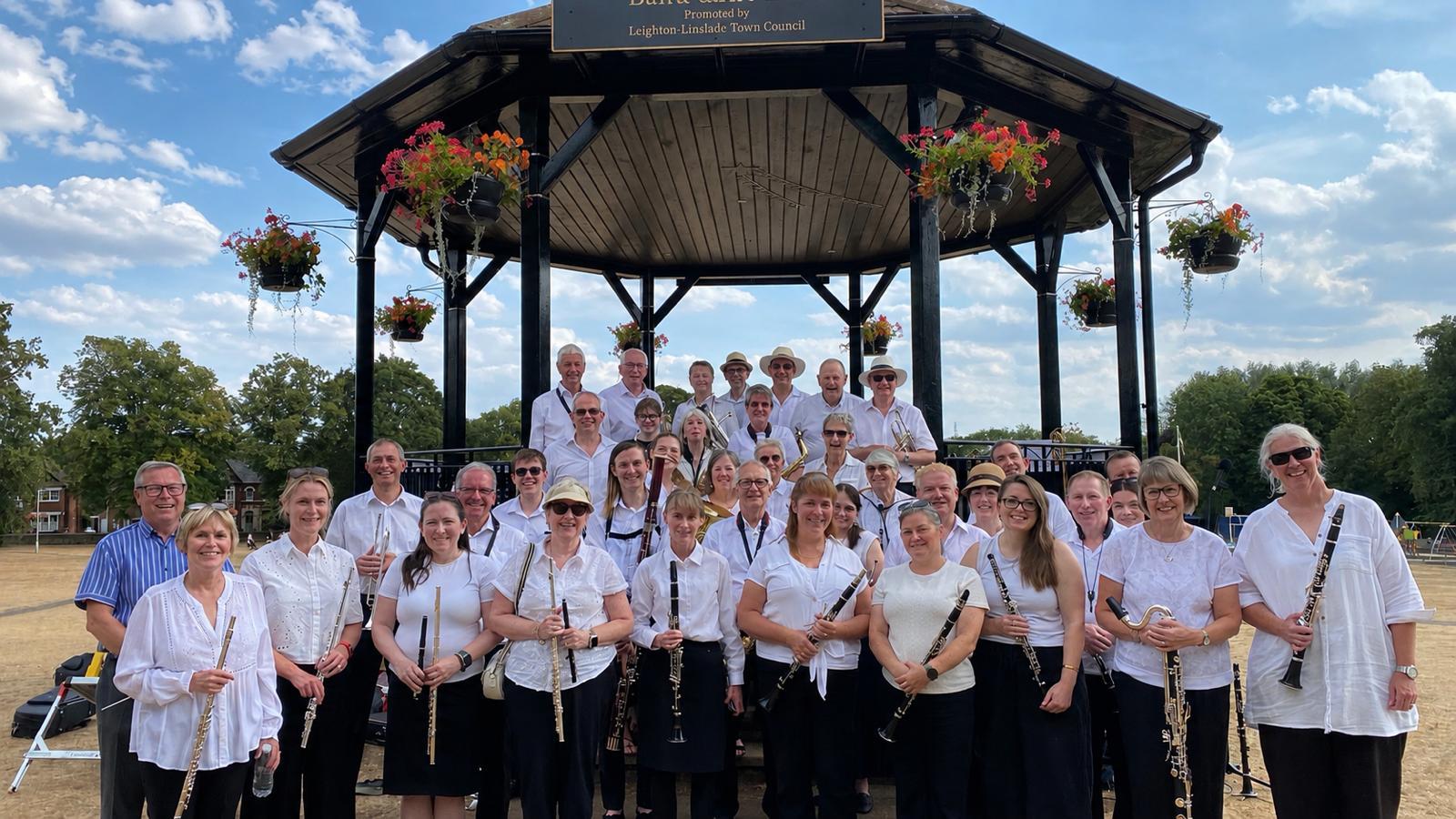 leighton linslade concert band lined up in white shirts at the bandstand in parsons close rec