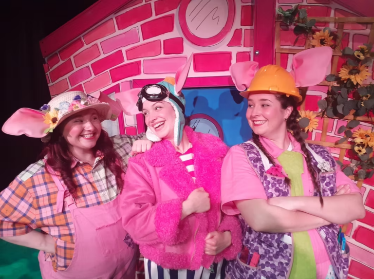 image of the cast of Three Little Pigs lost the Plot production dressed in bright pink outfits with funny pig ears